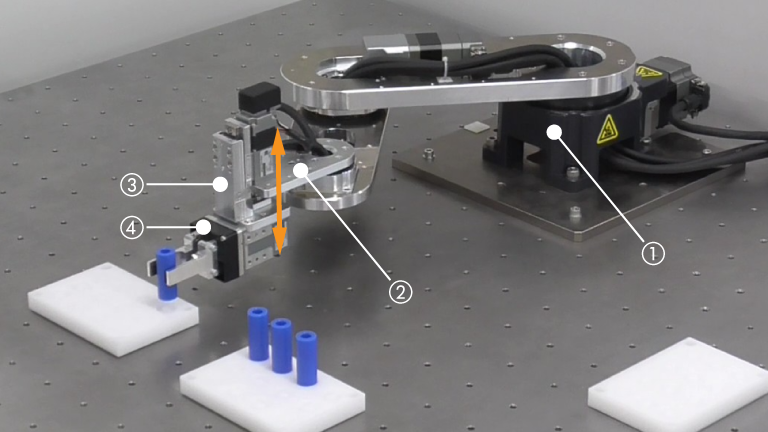 Example of OVR robot implementation. Photograph showing the installation of a robot performing picking operations on blue cylindrical workpieces inside an aluminum frame structure